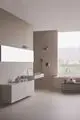 Moderne Badezimmeransicht mit eleganter Waschtischarmatur von Ideal Standard, integriert in eine minimalistische, helle Umgebung, einschließlich Waschbecken und Dusche.